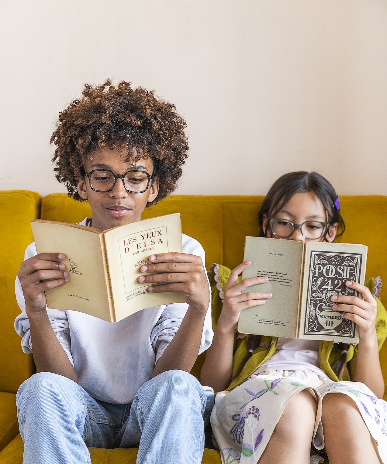 Zwei Kinder lesen auf einem Couch